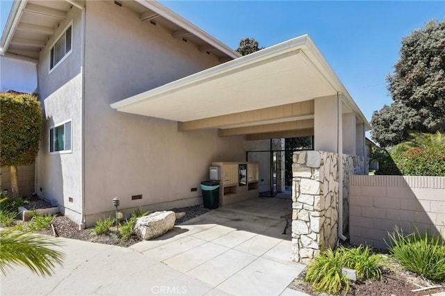3110 Merrill Dr Unit 67, Torrance, CA 90503 - view of side of home featuring stucco siding, crawl space, concrete driveway, and a carport