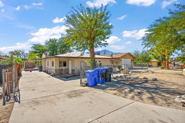 66229 4th St, Desert Hot Springs, CA 92240 - rear view of house featuring stone siding, concrete driveway, and stucco siding