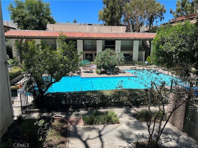 5460 White Oak Ave Unit G210, Encino, CA 91316 - rear view of property featuring stucco siding, a community pool, a patio, and a tiled roof