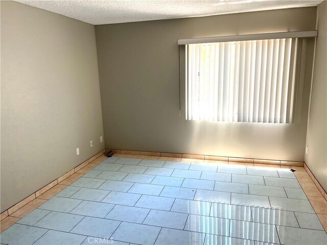 5460 White Oak Ave Unit G210, Encino, CA 91316 - tiled spare room with a textured ceiling and baseboards