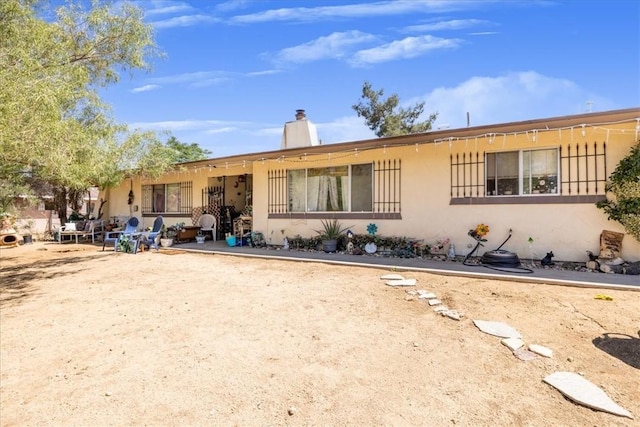 56455 Carlyle Dr, Yucca Valley, CA 92284 - view of front of house with stucco siding and a chimney