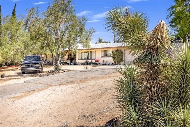 56455 Carlyle Dr, Yucca Valley, CA 92284 - view of front of house with a garage and dirt driveway