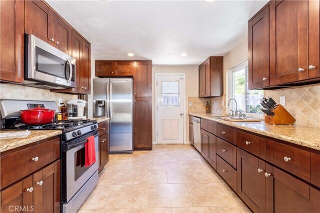2065 Medina Ave, Simi Valley, CA 93063 - kitchen with stainless steel appliances, a sink, backsplash, light stone counters, and recessed lighting