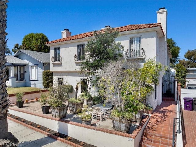 377 Roycroft Ave, Long Beach, CA 90814 - mediterranean / spanish-style house featuring a chimney, stucco siding, a patio, a balcony, and a tile roof