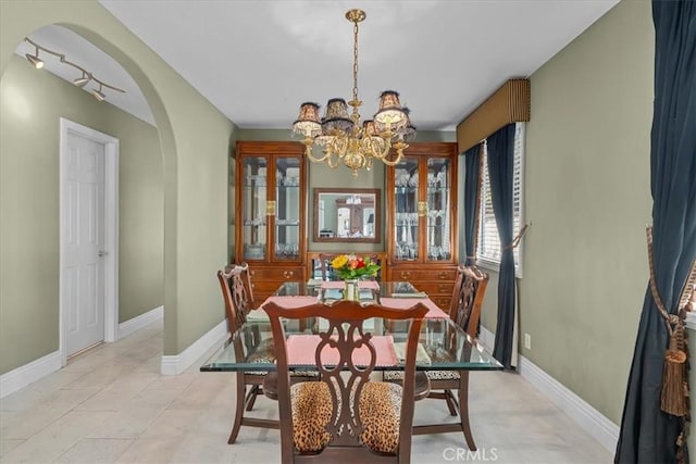 377 Roycroft Ave, Long Beach, CA 90814 - dining space featuring arched walkways, a chandelier, and baseboards