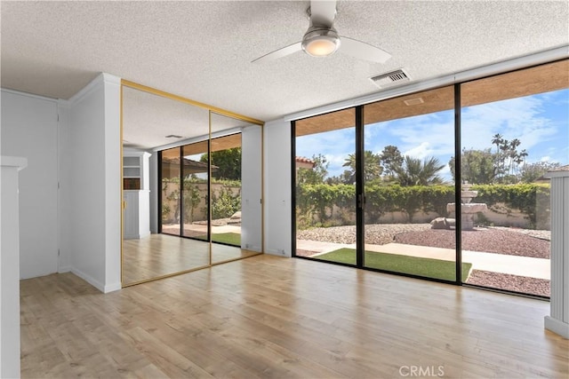 171 Yale Dr, Rancho Mirage, CA 92270 - unfurnished room featuring expansive windows, a textured ceiling, ceiling fan, and wood finished floors