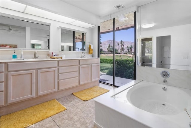 171 Yale Dr, Rancho Mirage, CA 92270 - bathroom with double vanity, tile patterned floors, a bath, a mountain view, and a ceiling fan