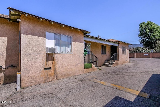12528 Bradley Ave, Los Angeles, CA 91342 - view of front facade featuring stucco siding, cooling unit, and uncovered parking