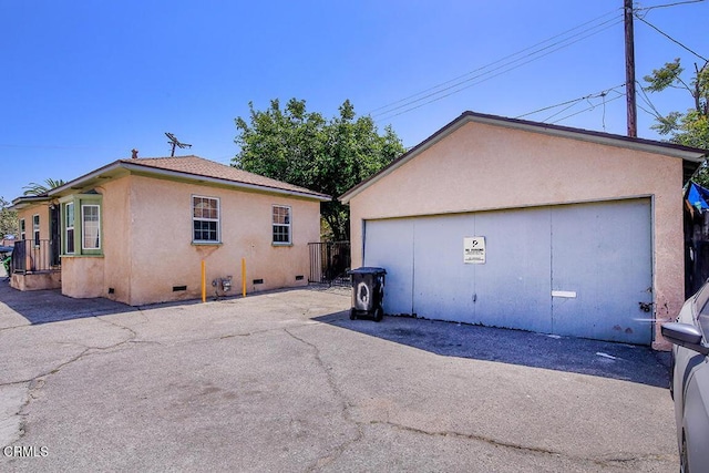 12528 Bradley Ave, Los Angeles, CA 91342 - view of property exterior featuring crawl space, stucco siding, a garage, and an outbuilding