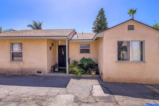 12528 Bradley Ave, Los Angeles, CA 91342 - view of front of home with stucco siding, crawl space, and a shingled roof