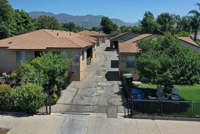 12528 Bradley Ave, Los Angeles, CA 91342 - view of front facade with a fenced front yard, a shingled roof, stucco siding, and a mountain view