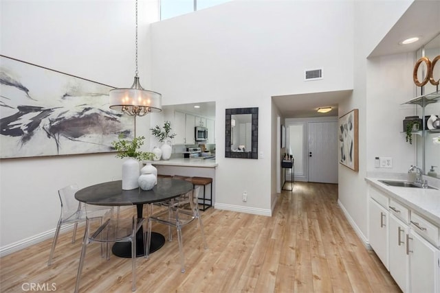 4 Dogwood N, Irvine, CA 92612 - dining space featuring a high ceiling, light wood-style floors, baseboards, a chandelier, and recessed lighting