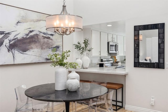 4 Dogwood N, Irvine, CA 92612 - dining room featuring a chandelier, baseboards, and light wood-style flooring