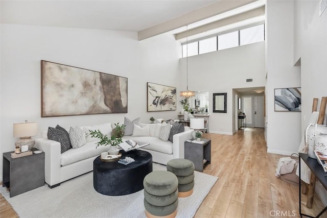 4 Dogwood N, Irvine, CA 92612 - living room featuring light wood-style flooring, baseboards, a chandelier, and a high ceiling