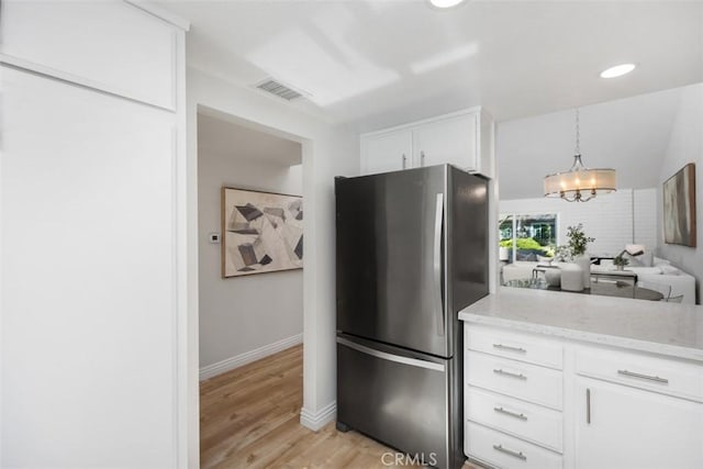 4 Dogwood N, Irvine, CA 92612 - kitchen with freestanding refrigerator, light wood-type flooring, light stone counters, white cabinetry, and decorative light fixtures