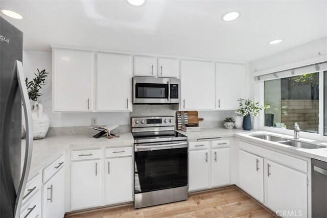 4 Dogwood N, Irvine, CA 92612 - kitchen with stainless steel appliances, a sink, light countertops, white cabinets, and recessed lighting