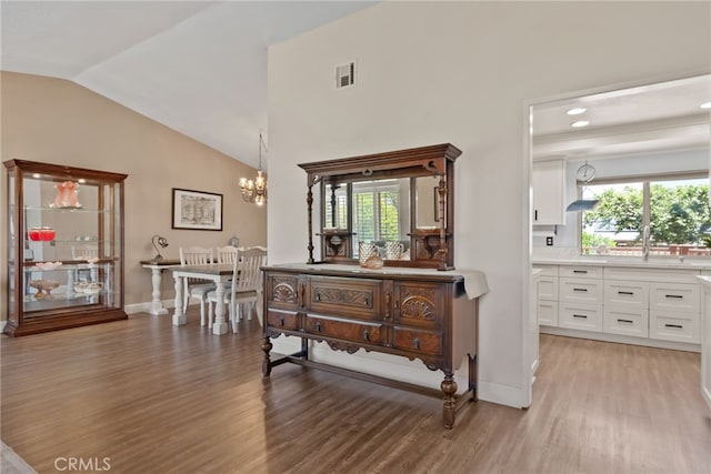 2619 S Castle Harbour Ave, Ontario, CA 91761 - hallway featuring light wood-style floors, lofted ceiling, a chandelier, a sink, and baseboards