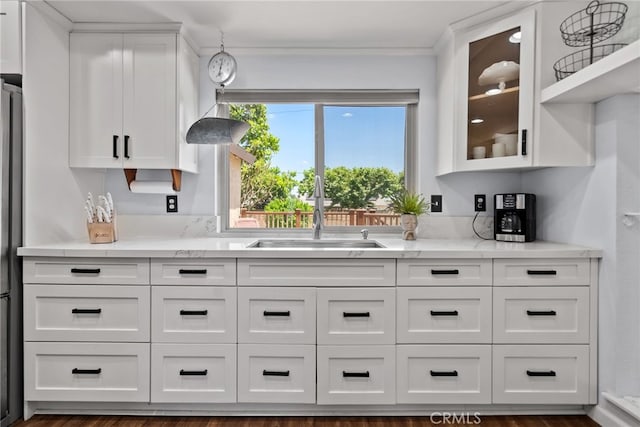 2619 S Castle Harbour Ave, Ontario, CA 91761 - kitchen featuring a sink, white cabinets, glass insert cabinets, crown molding, and light stone countertops