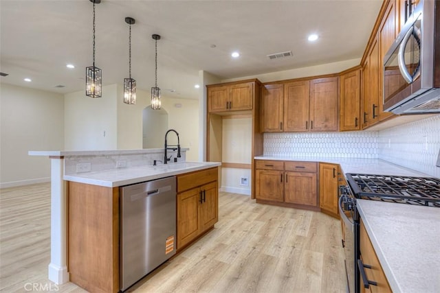 6210 Himmel St, Paradise, CA 95969 - kitchen featuring stainless steel appliances, a sink, brown cabinets, light wood-type flooring, and recessed lighting