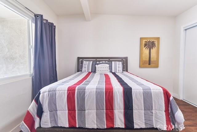 68600 E St, Cathedral City, CA 92234 - bedroom featuring multiple windows, beamed ceiling, and wood finished floors