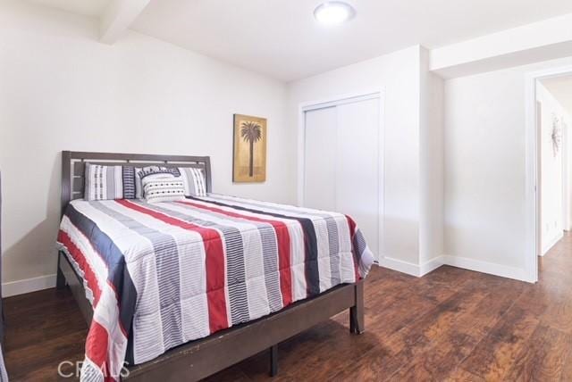 68600 E St, Cathedral City, CA 92234 - bedroom featuring baseboards, wood finished floors, beam ceiling, and a closet