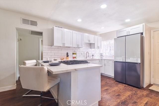 68600 E St, Cathedral City, CA 92234 - kitchen with fridge, white cabinetry, dark wood-style floors, decorative backsplash, and gas stovetop