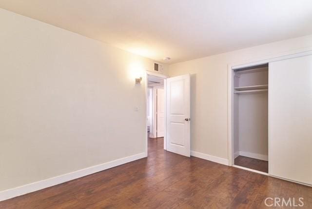68600 E St, Cathedral City, CA 92234 - unfurnished bedroom with wood finished floors, a closet, and baseboards