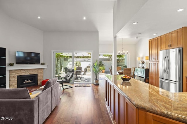 483 Broderick Way, Port Hueneme, CA 93041 - kitchen featuring freestanding refrigerator, open floor plan, light stone counters, dark wood-style flooring, and a stone fireplace