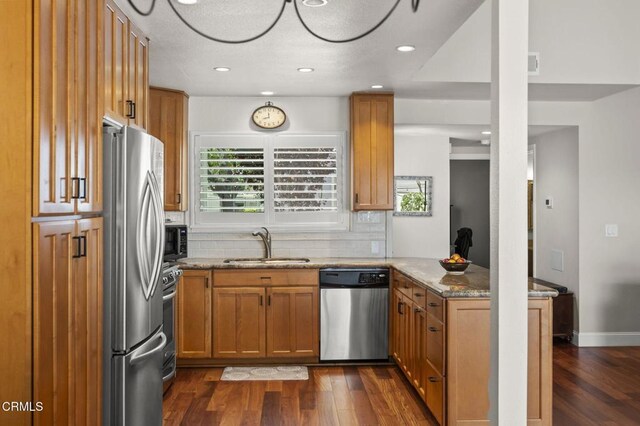 483 Broderick Way, Port Hueneme, CA 93041 - kitchen with stainless steel appliances, a sink, a peninsula, dark wood-style floors, and light stone counters