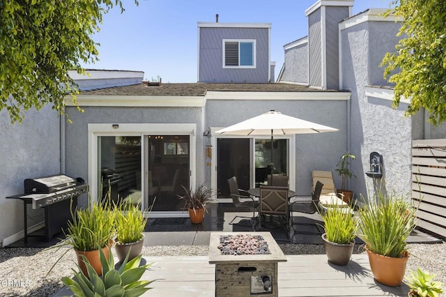 483 Broderick Way, Port Hueneme, CA 93041 - rear view of house featuring an outdoor fire pit, stucco siding, a chimney, a wooden deck, and a patio area