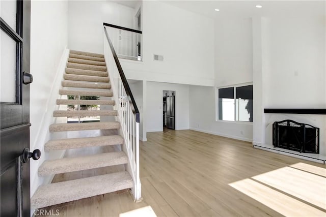 968 N Darfield Ave, Covina, CA 91724 - stairs with a towering ceiling, wood finished floors, baseboards, a fireplace, and recessed lighting