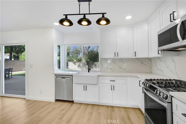 968 N Darfield Ave, Covina, CA 91724 - kitchen with appliances with stainless steel finishes, a sink, light wood-type flooring, tasteful backsplash, and white cabinets