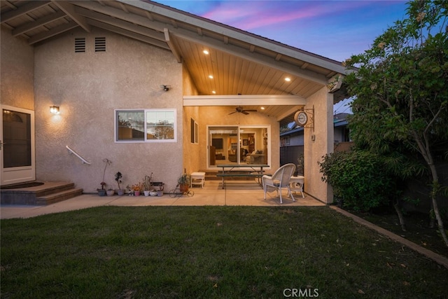 5323 Fidler Ave, Lakewood, CA 90712 - back of property at dusk with ceiling fan, stucco siding, and a patio