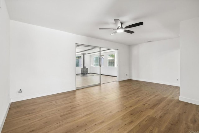 6443 Mount Ackerman Dr, San Diego, CA 92111 - spare room featuring ceiling fan, wood finished floors, baseboards, and a wood stove
