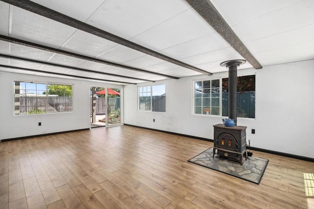 6443 Mount Ackerman Dr, San Diego, CA 92111 - unfurnished living room with a wood stove, beam ceiling, wood finished floors, and baseboards