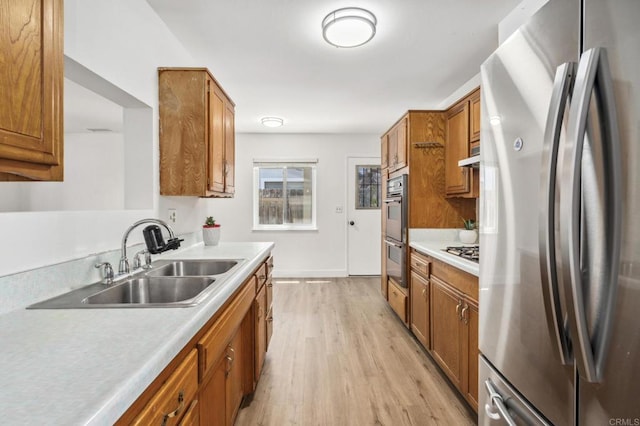 6443 Mount Ackerman Dr, San Diego, CA 92111 - kitchen featuring stainless steel appliances, a sink, brown cabinetry, and light wood-style floors