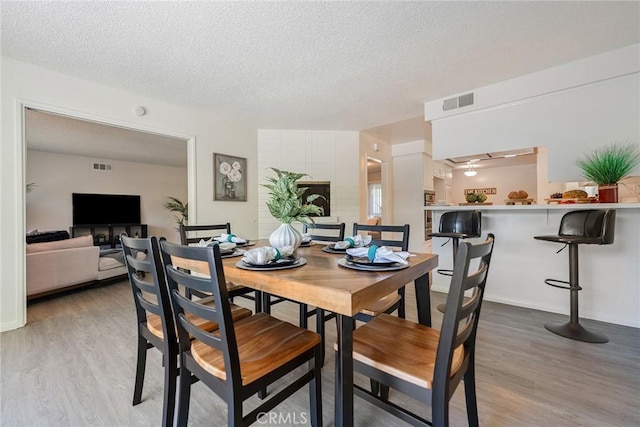 557 S Gardner Dr, Orange, CA 92866 - dining room with light wood-style floors, a textured ceiling, and baseboards