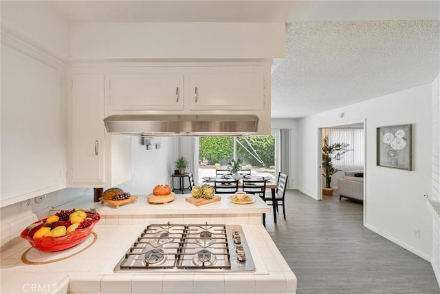 557 S Gardner Dr, Orange, CA 92866 - kitchen with tile countertops, stainless steel gas stovetop, white cabinetry, wood finished floors, and a textured ceiling