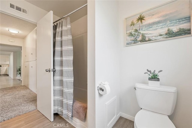 557 S Gardner Dr, Orange, CA 92866 - full bath featuring toilet, wood finished floors, curtained shower, and baseboards