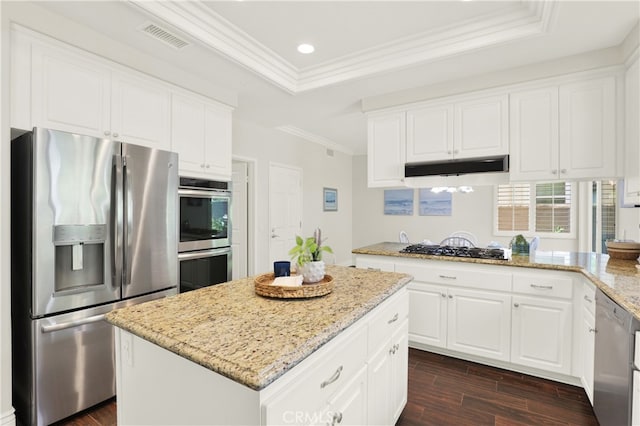 4 Westgate, Laguna Niguel, CA 92677 - kitchen with appliances with stainless steel finishes, under cabinet range hood, a raised ceiling, dark wood-style flooring, and ornamental molding