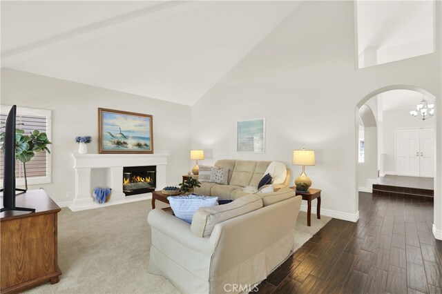 4 Westgate, Laguna Niguel, CA 92677 - living room featuring arched walkways, high vaulted ceiling, baseboards, a glass covered fireplace, and wood finished floors