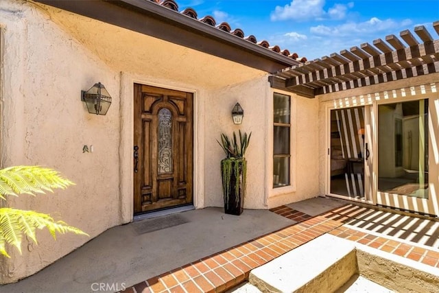 24155 Vis D Onde, Dana Point, CA 92629 - view of exterior entry featuring stucco siding, a pergola, and a tile roof