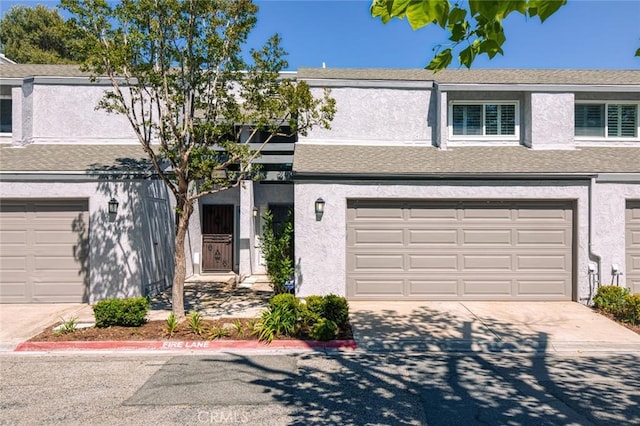 4906 W 5th St Unit C, Santa Ana, CA 92703 - view of property with an attached garage, stucco siding, and concrete driveway