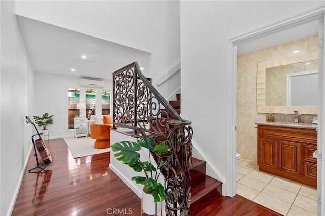 4906 W 5th St Unit C, Santa Ana, CA 92703 - stairway featuring an AC wall unit, wood finished floors, recessed lighting, tile walls, and baseboards