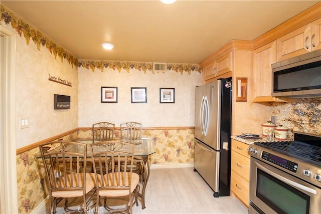 21357 Bermuda St, Chatsworth, CA 91311 - kitchen with stainless steel appliances, light brown cabinets, wallpapered walls, baseboards, and light countertops