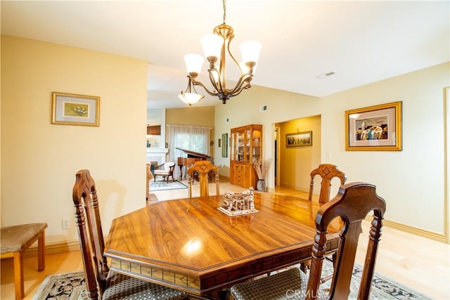 21357 Bermuda St, Chatsworth, CA 91311 - dining space with a chandelier, baseboards, vaulted ceiling, and light wood-style floors
