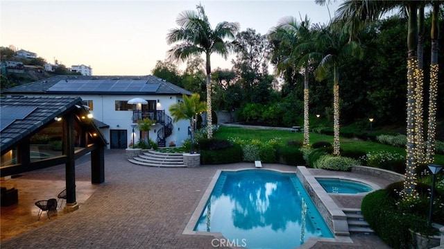 10372 Crawford Canyon Rd, North Tustin, CA 92705 - pool at dusk featuring stairs, a patio area, a deck, a lawn, and a pool with connected hot tub