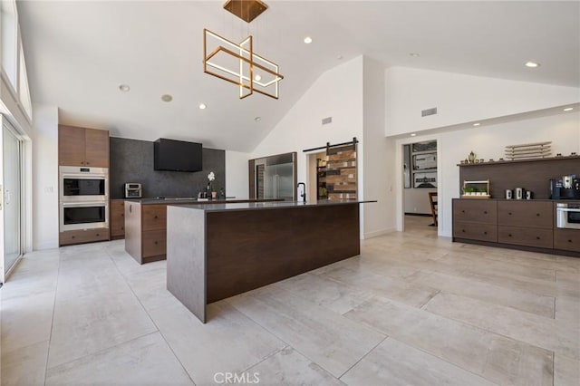 10372 Crawford Canyon Rd, North Tustin, CA 92705 - kitchen with modern cabinets, stainless steel appliances, a kitchen island with sink, high vaulted ceiling, and a barn door
