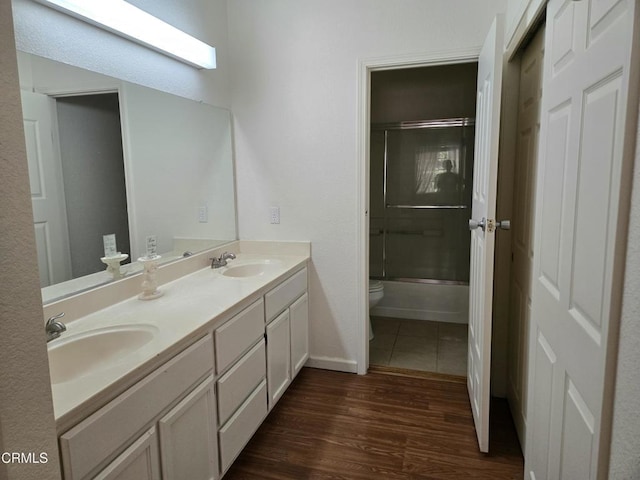 1174 Greene Ter, Davis, CA 95618 - full bathroom with toilet, double vanity, wood finished floors, baseboards, and enclosed tub / shower combo