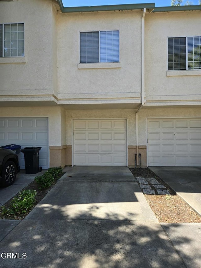 1174 Greene Ter, Davis, CA 95618 - view of property featuring a garage, stucco siding, and driveway